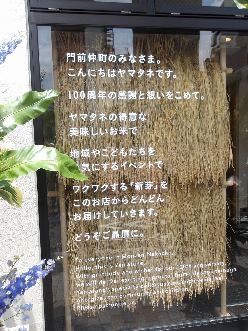 ヤマタネ「新芽の便り」店舗外観、ガラス越しにハゼかけした稲